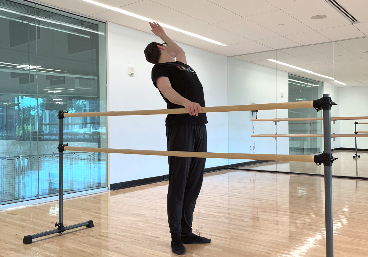 Ballet instructor Brendan Behan demonstrates a cambré arch at the ballet bar inside the dance studio at the Robert Crown Community Center.