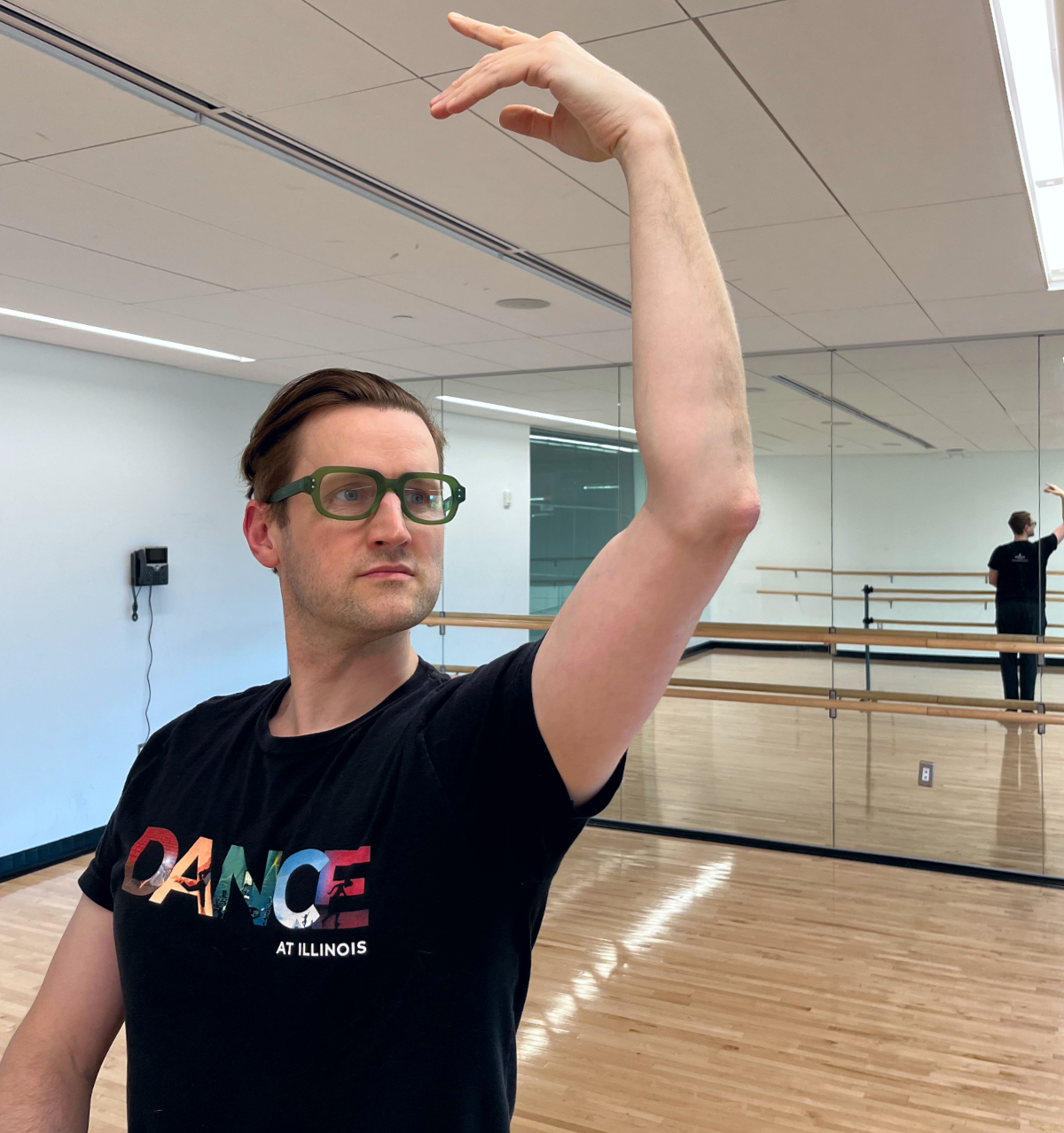 Ballet instructor Brendan Behan demonstrates a port-au-bras arm position at the ballet bar inside the dance studio at the Robert Crown Community Center.
