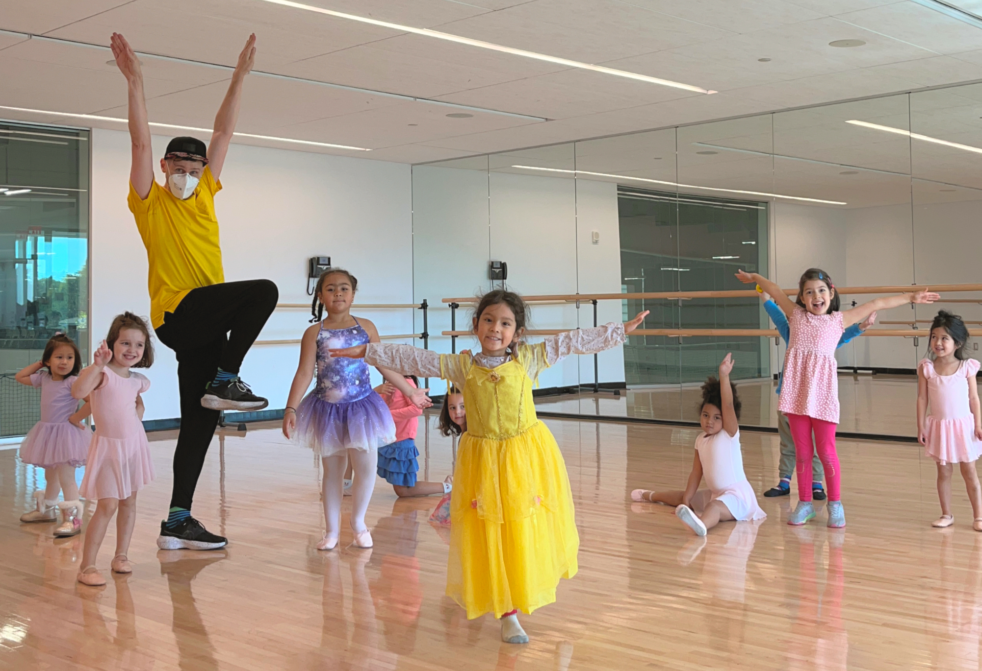 Teacher Brendan Behan and students smiling and posing inside the dance studio.