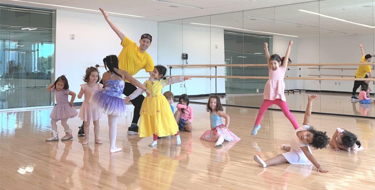 Mr. Brendan and students smiling and posing inside the dance studio.