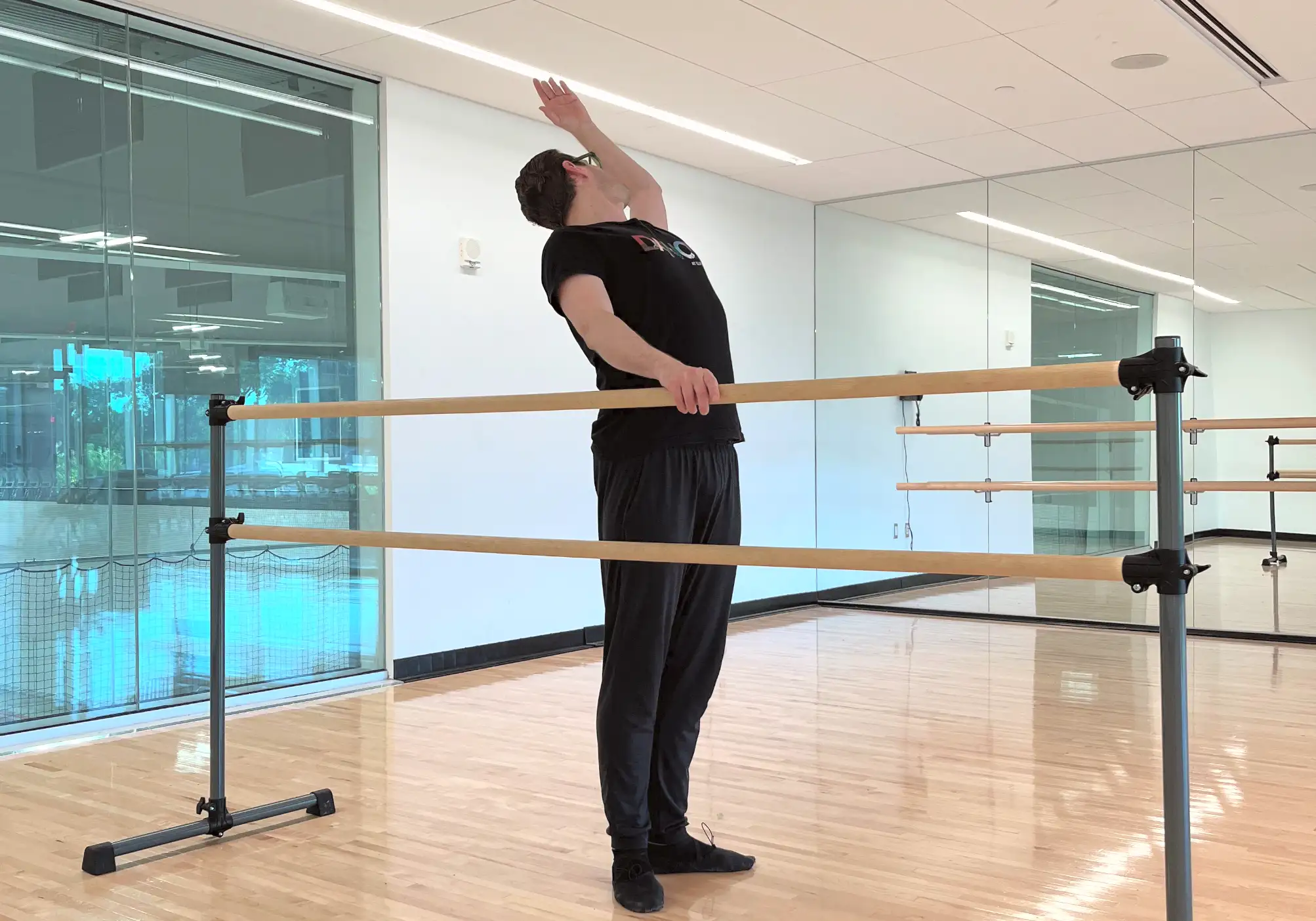 Ballet instructor Brendan Behan demonstrates a cambré arch at the ballet bar inside the dance studio at the Robert Crown Community Center.